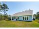 Back exterior of home with screened porch and well-maintained lawn at 2036 Yaupon Way, Johns Island, SC 29455