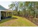 Landscaped backyard with an enclosed porch and black metal fencing at 2036 Yaupon Way, Johns Island, SC 29455