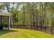Landscaped backyard featuring a black metal fence surrounding a wooded area at 2036 Yaupon Way, Johns Island, SC 29455