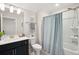A bathroom featuring a shower/tub combo with a blue shower curtain, a white sink, and a dark blue vanity at 2036 Yaupon Way, Johns Island, SC 29455