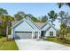 Charming single-story home featuring light blue siding, gray garage doors and a well-manicured lawn at 2036 Yaupon Way, Johns Island, SC 29455