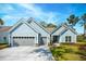 Charming single-story home featuring light blue siding, gray garage doors and a well-manicured lawn at 2036 Yaupon Way, Johns Island, SC 29455