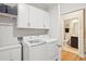 Laundry room with white cabinets, modern washer/dryer, and an adjacent bathroom at 2036 Yaupon Way, Johns Island, SC 29455