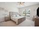 This is a light and bright main bedroom with a ceiling fan, neutral carpet, and a large window overlooking a yard at 2036 Yaupon Way, Johns Island, SC 29455