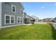 Expansive backyard featuring a white picket fence, screened in patio, and lush green grass at 204 Corvus St, Summerville, SC 29483