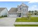 Charming home featuring a well-maintained lawn, a two car garage, and light blue siding at 204 Corvus St, Summerville, SC 29483