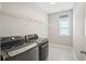 Bright laundry room with modern washer and dryer, shelving and tile floor at 204 Corvus St, Summerville, SC 29483