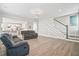 Open concept living area with comfortable seating, staircase accent wall, and kitchen in the background at 204 Corvus St, Summerville, SC 29483