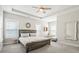 Bright main bedroom featuring a wooden bed frame, tray ceiling, and neutral color scheme at 204 Corvus St, Summerville, SC 29483