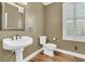 Elegant powder room featuring pedestal sink, wood floors and a framed mirror at 2093 Rookery Ln, Charleston, SC 29414