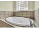 A large soaking tub is featured beneath a privacy glass window at 2093 Rookery Ln, Charleston, SC 29414