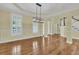 Open-concept dining and living area with hardwood floors, detailed molding, and a modern light fixture at 2093 Rookery Ln, Charleston, SC 29414