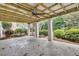 Covered patio with concrete columns and ceiling fan, offering a shady retreat in a lush backyard at 2093 Rookery Ln, Charleston, SC 29414