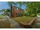 Brick townhome with a well-maintained lawn, mature trees, and a brick-lined garden bed at 21 Hester St # Apt 12, Charleston, SC 29403