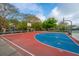 Outdoor basketball court features vibrant red and blue play area with basketball hoop, bordered by mature trees at 21 Hester St # Apt 12, Charleston, SC 29403