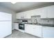 Bright kitchen features white cabinets, stone backsplash and black appliances, offering modern convenience at 21 Hester St # Apt 12, Charleston, SC 29403