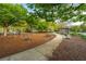 A vibrant community playground with swings, picnic tables, and park benches surrounded by lush greenery and a winding path at 21 Hester St # Apt 12, Charleston, SC 29403