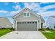View of a gray two-car garage with a concrete driveway and a well-manicured lawn at 214 Garden Gate Way, Summerville, SC 29486