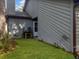 A view of the side and back of a home, including a grassy area and access to utilities at 2196 Spoleto Ln, North Charleston, SC 29406