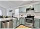Updated kitchen features aqua cabinets, stainless steel appliances, and a breakfast bar at 2196 Spoleto Ln, North Charleston, SC 29406
