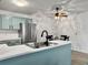 Modern kitchen features aqua cabinets, stainless steel refrigerator, and adjacent dining area at 2196 Spoleto Ln, North Charleston, SC 29406