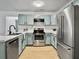 Bright kitchen with aqua cabinets, stainless steel refrigerator, and sleek black faucet at 2196 Spoleto Ln, North Charleston, SC 29406