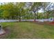 Large backyard features a lush lawn, mature trees, a white fence and comfortable swing at 2233 Glendale Dr, Charleston, SC 29414