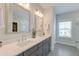 Bright bathroom featuring double sinks, sleek gray cabinetry, quartz countertops, and modern lighting fixtures at 2237 Tillage St, Mount Pleasant, SC 29466