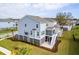 Rear exterior view featuring a screened-in porch, patio and a lush green yard surrounding the light blue house at 2237 Tillage St, Mount Pleasant, SC 29466