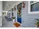 Inviting front porch featuring stylish lanterns, comfortable seating, and a welcoming blue door at 2237 Tillage St, Mount Pleasant, SC 29466