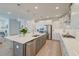 This spacious kitchen features stainless appliances, an island with sink, white cabinets, and a light wood floor at 2237 Tillage St, Mount Pleasant, SC 29466