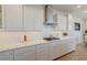 This kitchen has a white countertop and backsplash, stainless vent, and white cabinets with silver-finished drawer pulls at 2237 Tillage St, Mount Pleasant, SC 29466