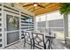 This screened-in porch has comfortable seating, a mounted flat-screen TV, ceiling fan, and brick floor at 2237 Tillage St, Mount Pleasant, SC 29466