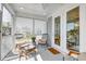Relaxing screened-in porch with neutral-toned chairs and throw pillows, plus a welcome mat for comfortable outdoor living at 2237 Tillage St, Mount Pleasant, SC 29466