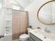 Bright bathroom with a round mirror, shower and tub combo, and gray vanity at 2632 Private Lefler Dr, Johns Island, SC 29455