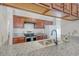Galley kitchen with modern appliances, granite countertops, stainless steel sink and a view into the dining room at 2777 Forest Dew Ct, Charleston, SC 29414