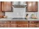 Contemporary kitchen featuring a stainless steel range hood, granite counters and dark wood cabinetry at 280 Swamp Creek Ln, Moncks Corner, SC 29461