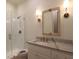 Modern bathroom featuring a marble vanity, decorative mirror, and frameless glass shower with gold hardware at 295 W Coleman Blvd, Mount Pleasant, SC 29464