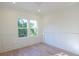 Bright bedroom featuring white trim, wainscoting, and two large windows with natural light and wood floors at 295 W Coleman Blvd, Mount Pleasant, SC 29464