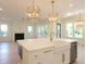Bright kitchen island with a white farmhouse sink, gold fixtures, marble countertops, and stylish pendant lighting at 295 W Coleman Blvd, Mount Pleasant, SC 29464