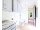 Laundry room with white cabinets and trim, marble countertop, bench, and light wood floors at 295 W Coleman Blvd, Mount Pleasant, SC 29464