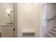 Bright mudroom with neutral walls, herringbone patterned paneling, a bench, hooks, and access to the stairs and bathroom at 295 W Coleman Blvd, Mount Pleasant, SC 29464