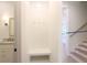 Bright mudroom with neutral walls, herringbone patterned paneling, a bench, hooks, and access to the stairs and bathroom at 295 W Coleman Blvd, Mount Pleasant, SC 29464