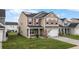 A view of a two story home featuring a two-car garage and well-manicured lawn at 320 Silverleaf Ln, Moncks Corner, SC 29461