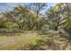 Backyard featuring lush lawn, mature trees, and a quaint patio area, creating an ideal setting for outdoor enjoyment at 322 Lantana Dr, Charleston, SC 29407
