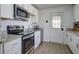 A well-lit kitchen features stainless steel appliances and granite countertops against bright white cabinetry at 322 Lantana Dr, Charleston, SC 29407