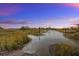Scenic waterfront view featuring a marsh, waterway, and colorful sunset at 322 Lantana Dr, Charleston, SC 29407