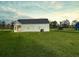 View of the home from the backyard, featuring a screened-in porch and lush lawn at 3292 N Highway 52, Saint Stephen, SC 29479