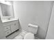 Bright bathroom featuring a white toilet and vanity, complemented by neutral walls and marble-look floor tiles at 3292 N Highway 52, Saint Stephen, SC 29479