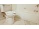 Bright bathroom features a toilet and tub with marble tiled floors at 3292 N Highway 52, Saint Stephen, SC 29479